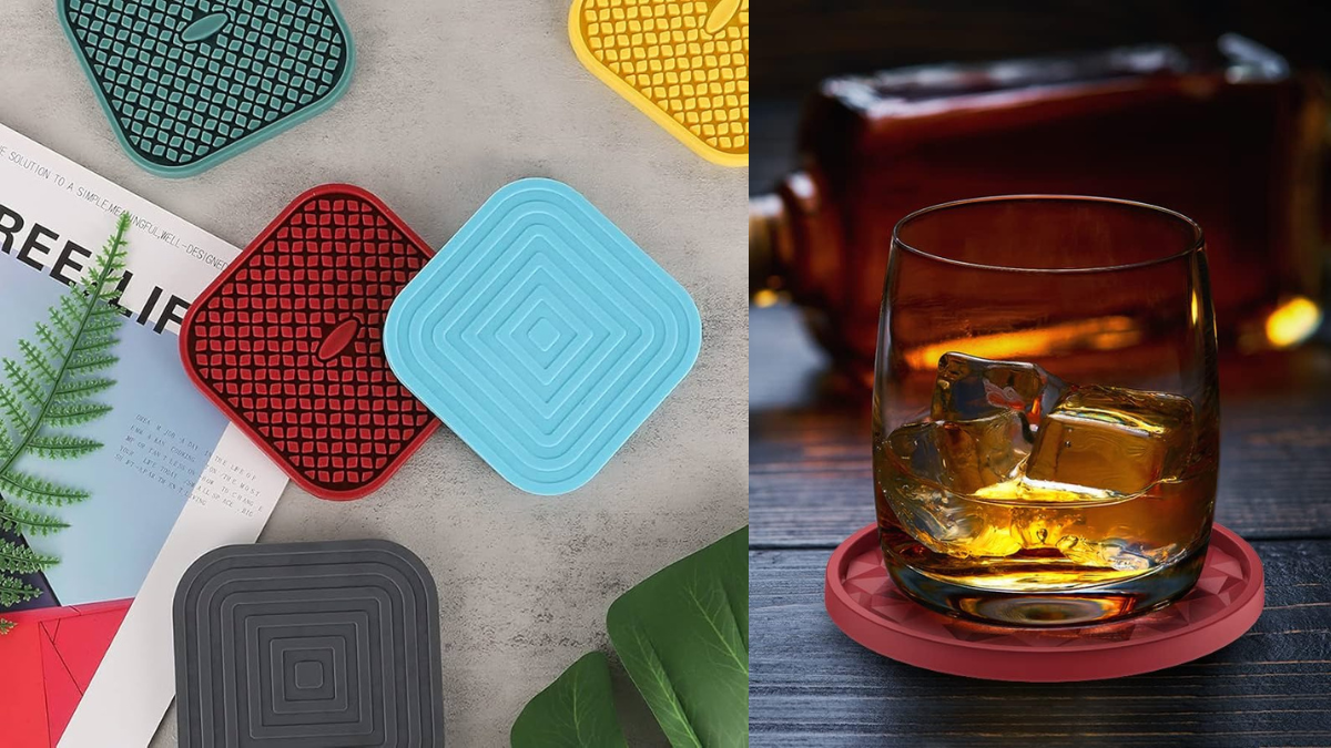 A set of colorful silicone drink coasters in various geometric patterns displayed on a table, with one coaster in use under a whiskey glass filled with ice.