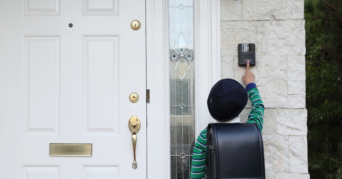 Ring video doorbell installed on home exterior with child ringing bell