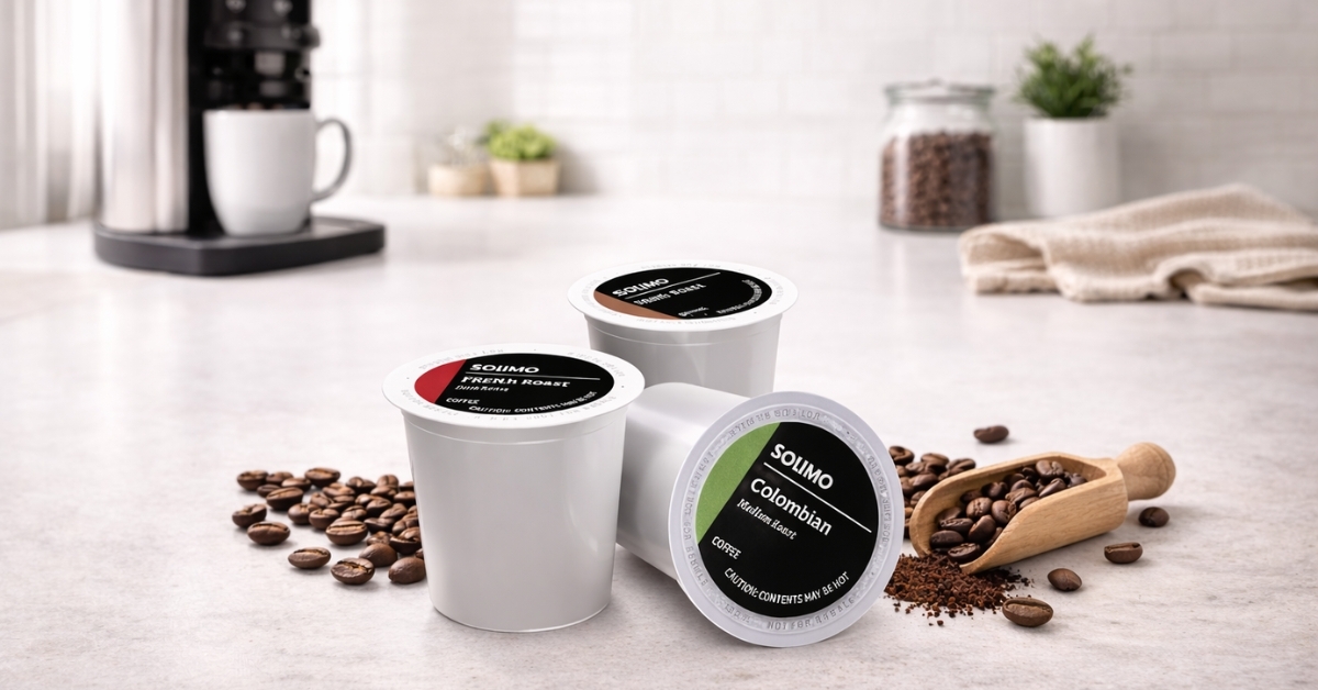 Amazon Solimo coffee pods with Colombian and French Roast flavors on kitchen counter beside coffee beans and Keurig machine